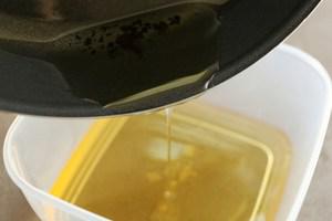 Cooking oil pouring into a plastic container