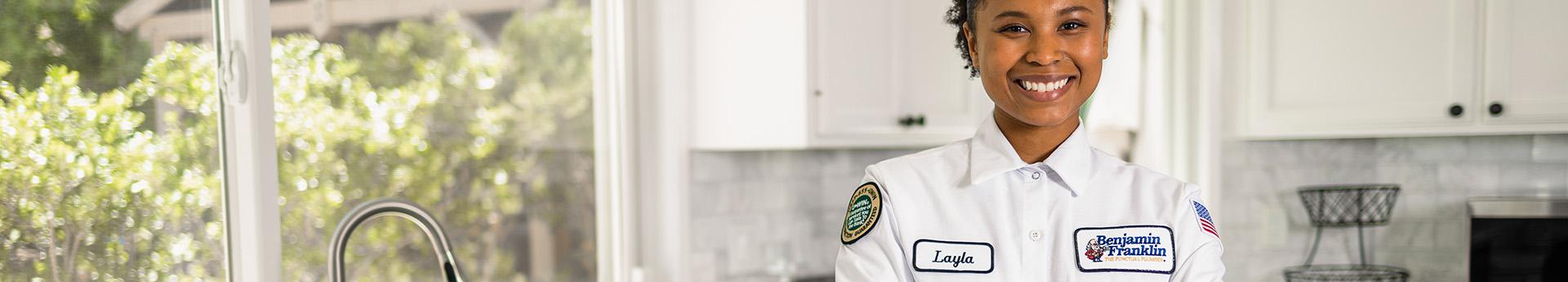 Smiling Benjamin Franklin Plumbing professional in a kitchen.