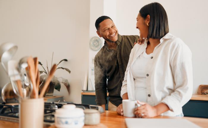 Man smiling with hand on woman's shoulder