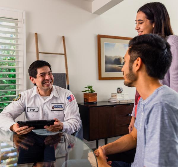 Plumber talking with a couple in home