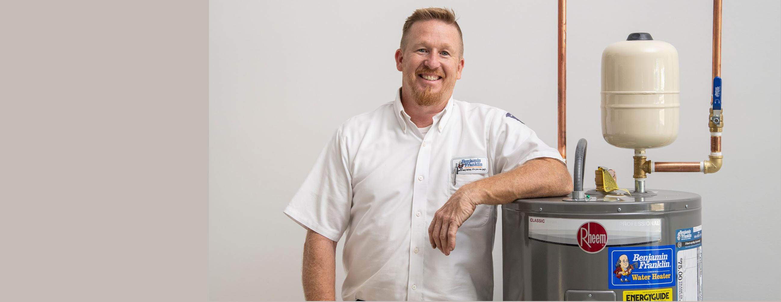 greenwood plumber standing by water heater