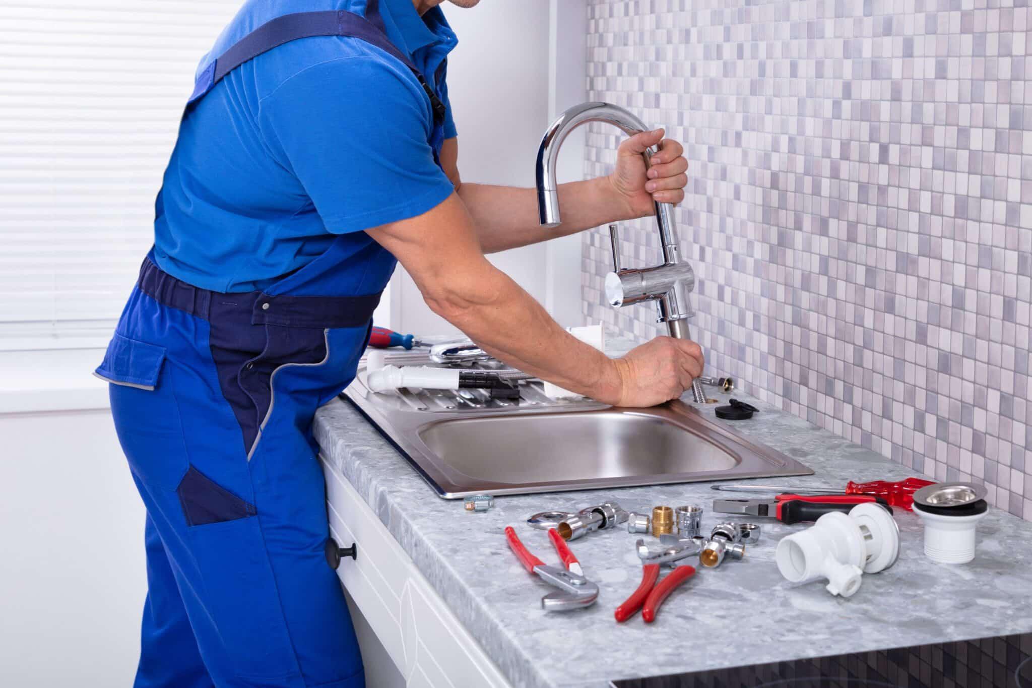 plumber installing kitchen faucet