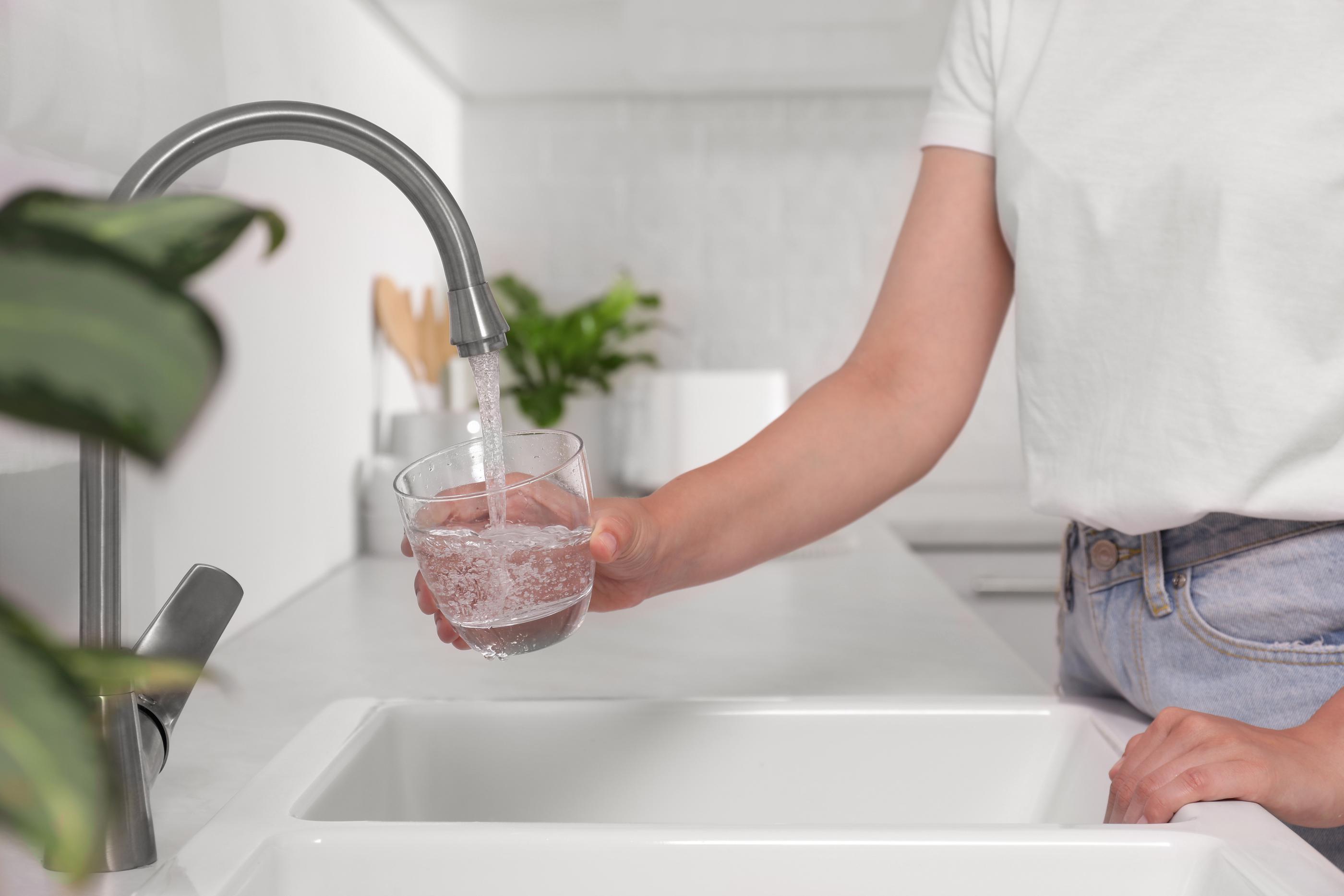 person filling up water glass