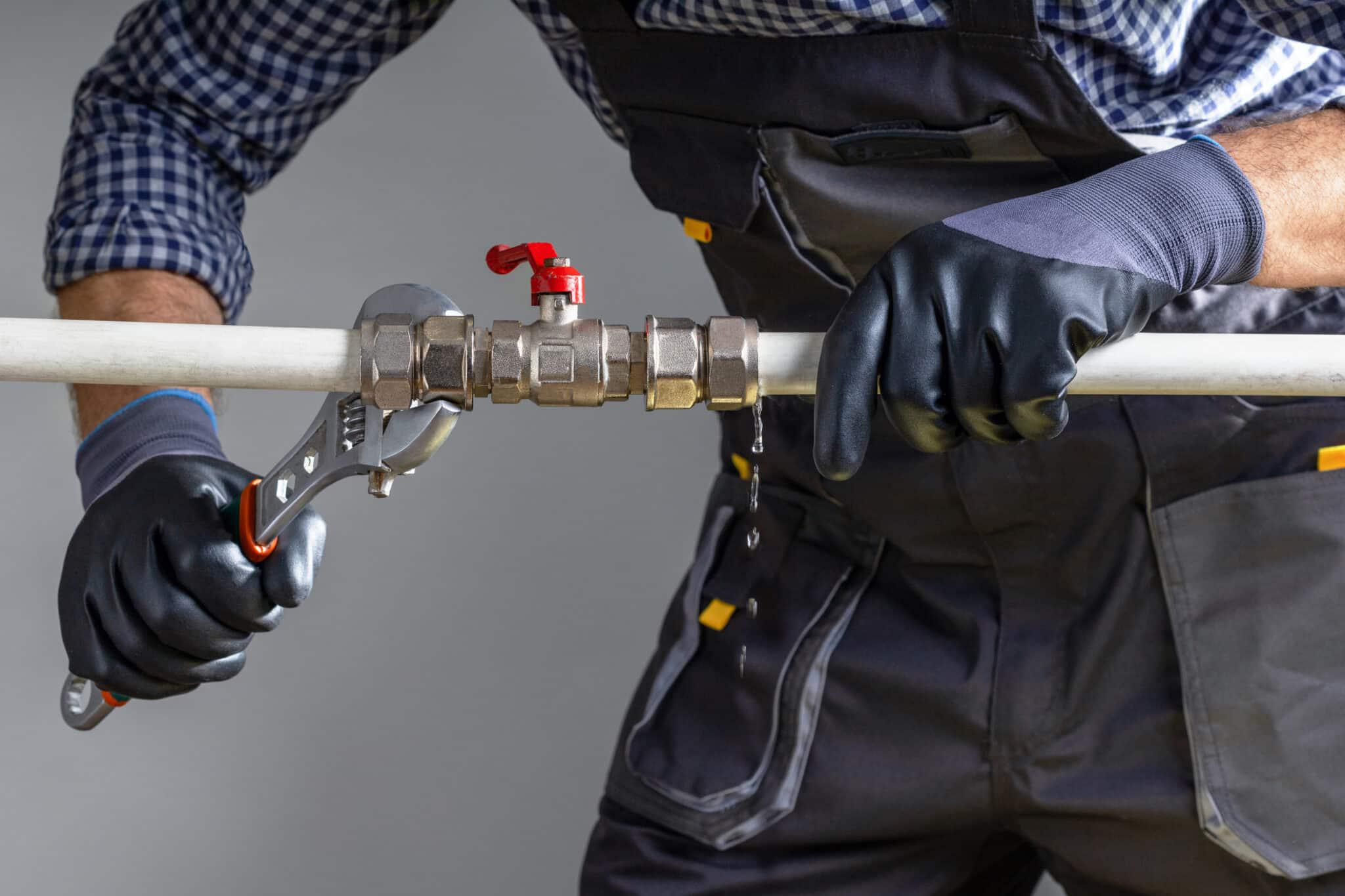 plumber tightening plumbing pipes
