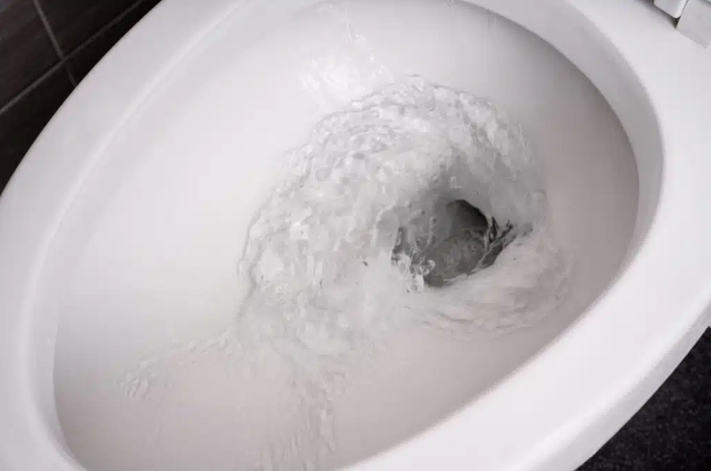 close up of toilet bowl flushing