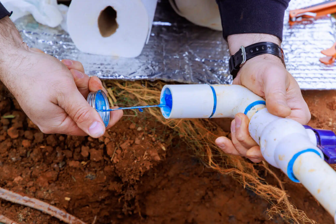 person putting blue solution in pipe