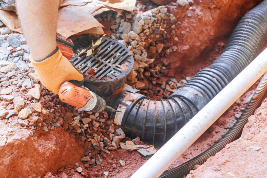 person drilling into draining pipe