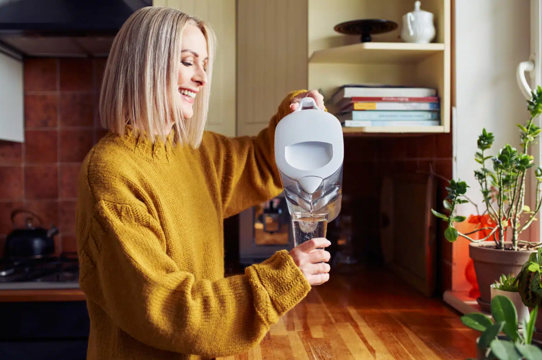 woman pouring water from a water pitcher