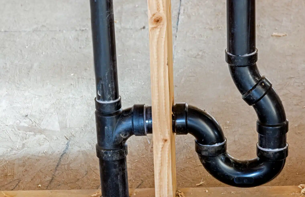 black piping plumbing with wooden stick