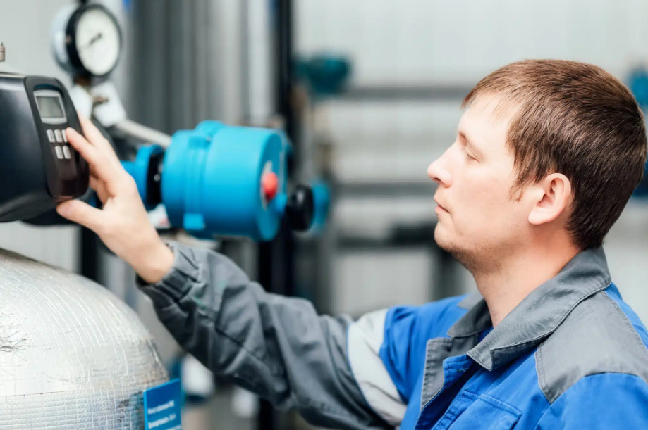 man pressing buttons on large plumbing system