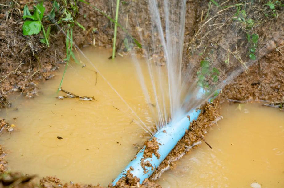 burst plumbing pipe in dirt and yellow water