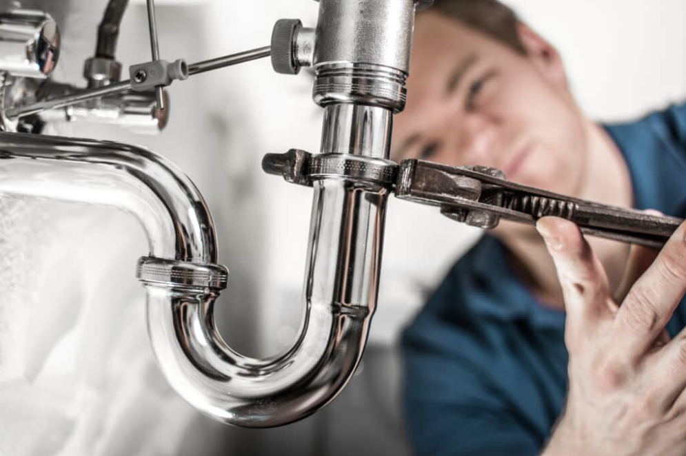 Plumber tightening pipe