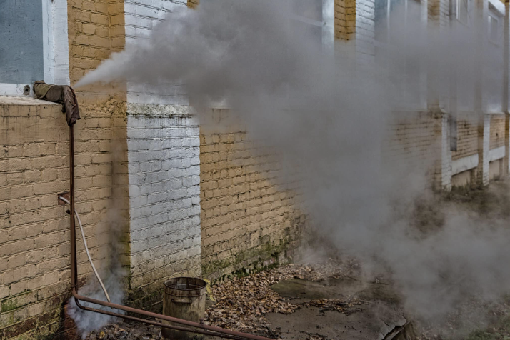 dark smoke coming from pipe on side of house