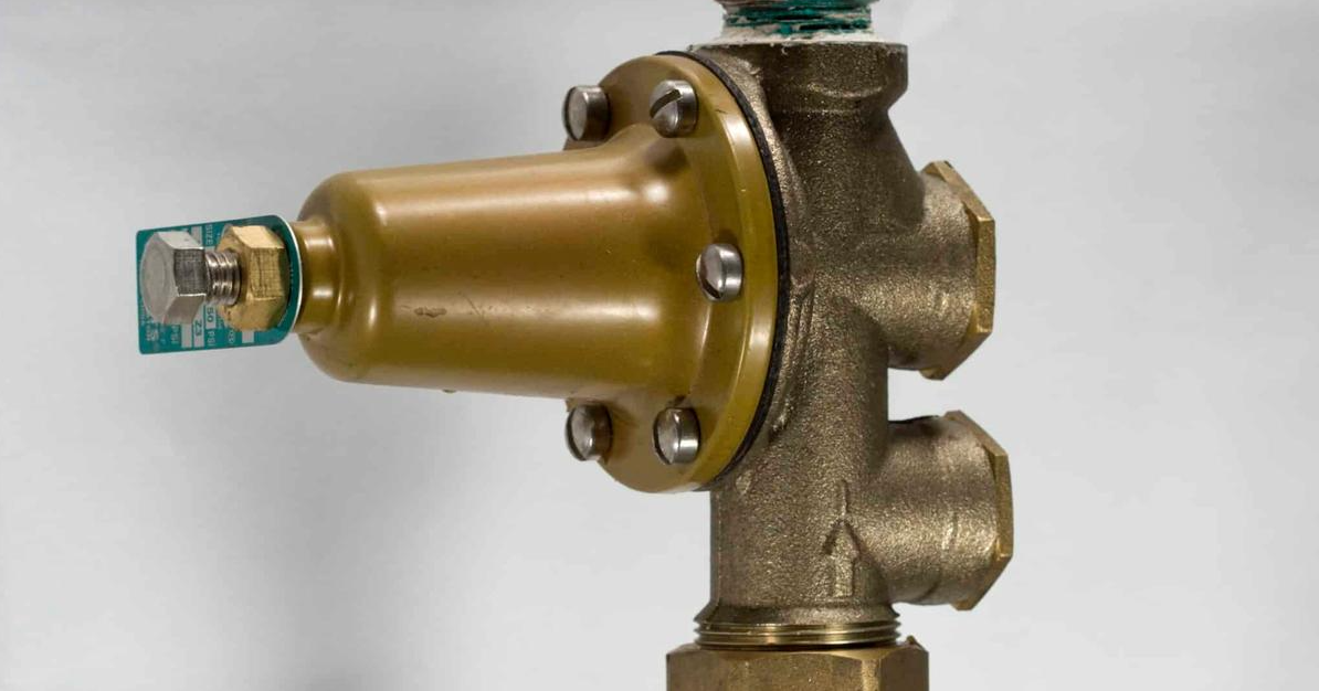 PRV (pressure reducing valve) installed on a main water line, with label pointing to it. A real job-site photo or clean diagram both work well here.
