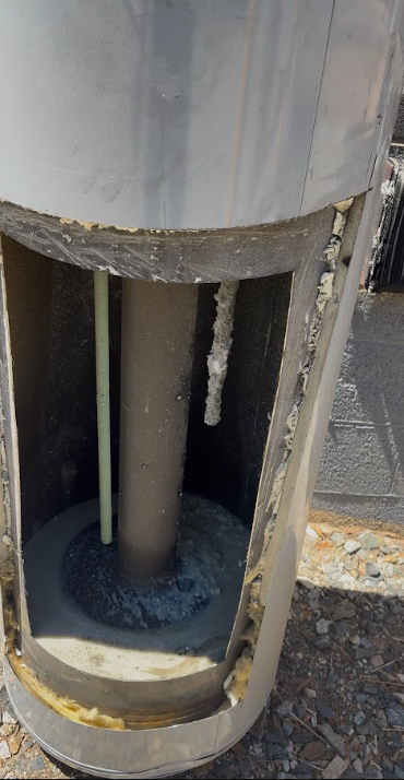 Cut-open water heater tank showing sediment layer at the bottom. Real job-site photo strongly preferred. This is a high-trust visual for this topic.