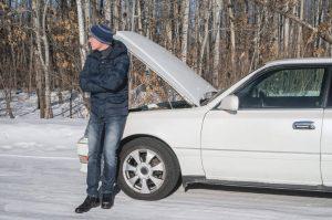 Man in front of broken down car