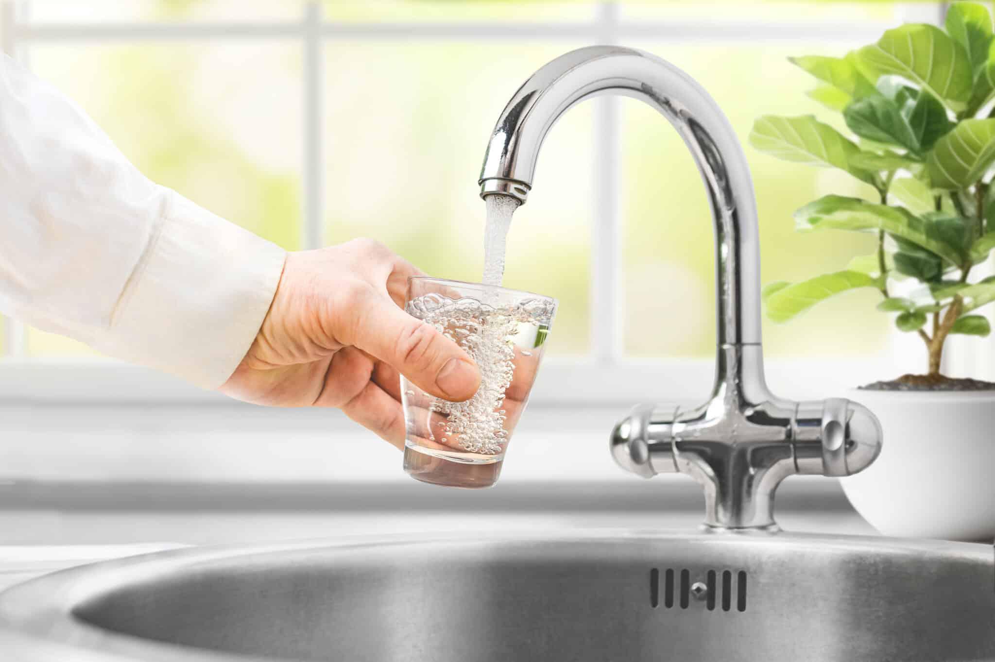 hand holding cup below water stream